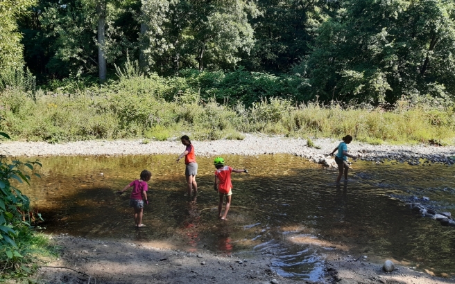 Photo : la famille joue dans une rivière ombragée